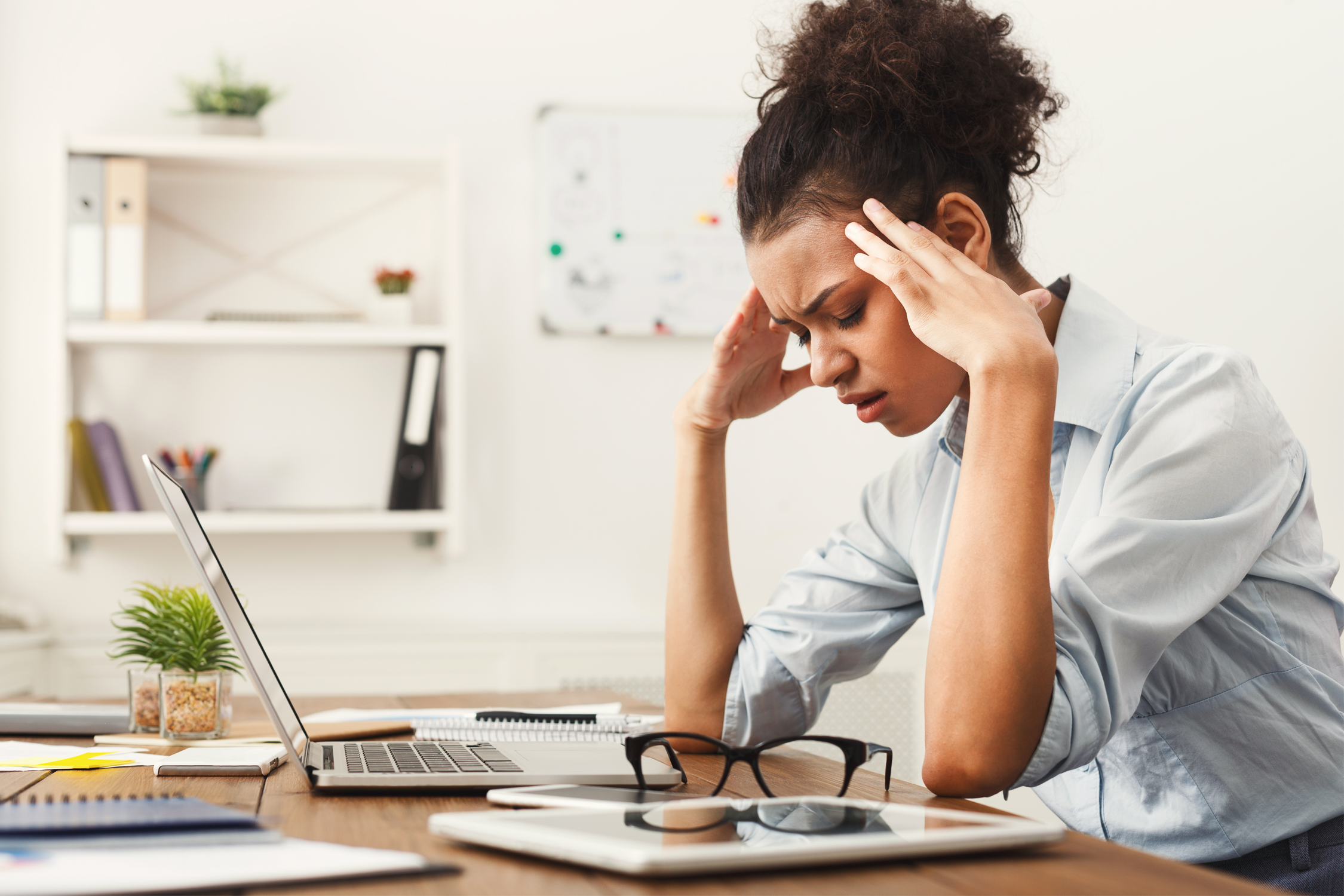 woman at laptop with stress headache