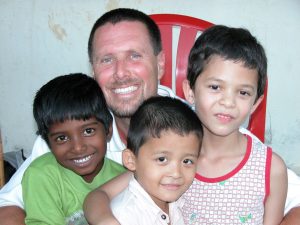 Gregory Moffatt with three children in India