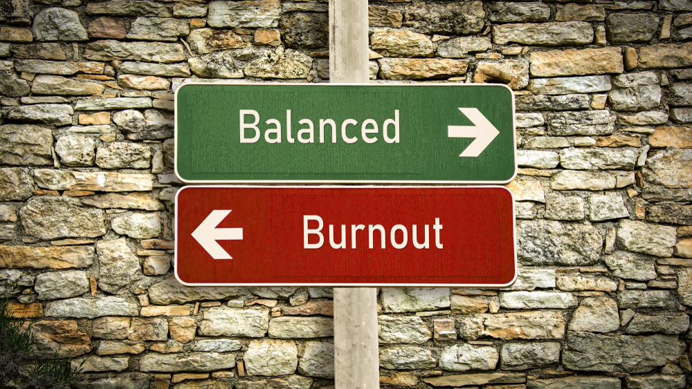A green sign saying &quot;balanced&quot; with an arrow pointing to the right and a red sign saying &quot;burnout&quot; with an arrow pointing to the left